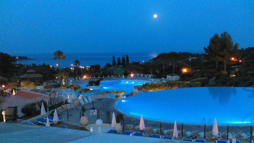 a view of a swimming pool at night at Cap Esterel vue Mer in Agay - Saint Raphael