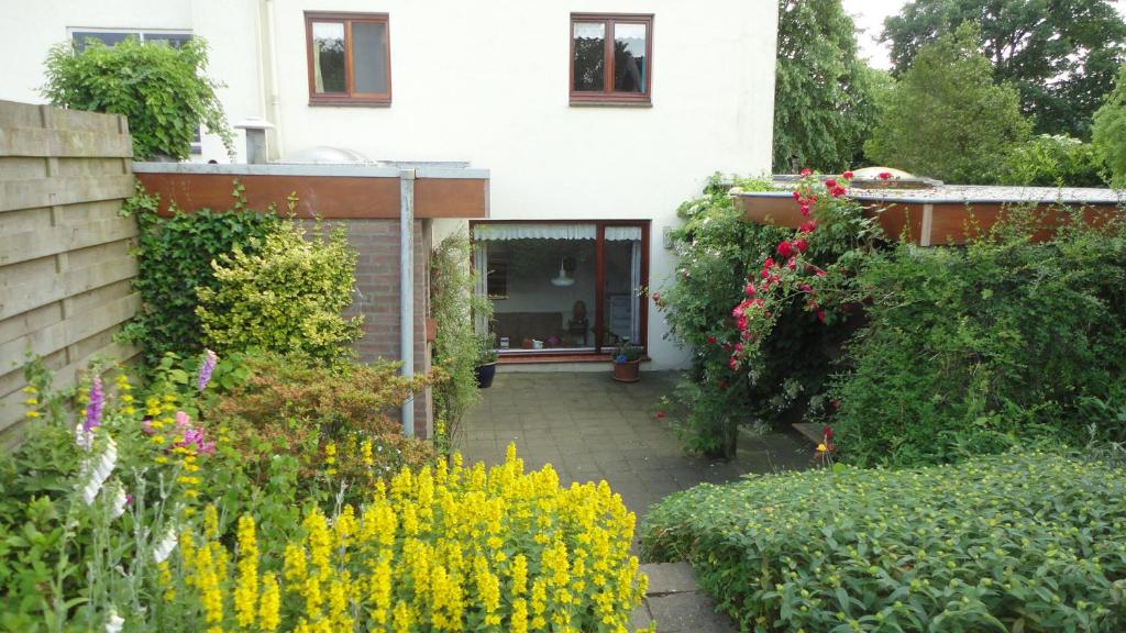 a garden in front of a house with flowers at Lardinois vakantieverhuur in Beutenaken