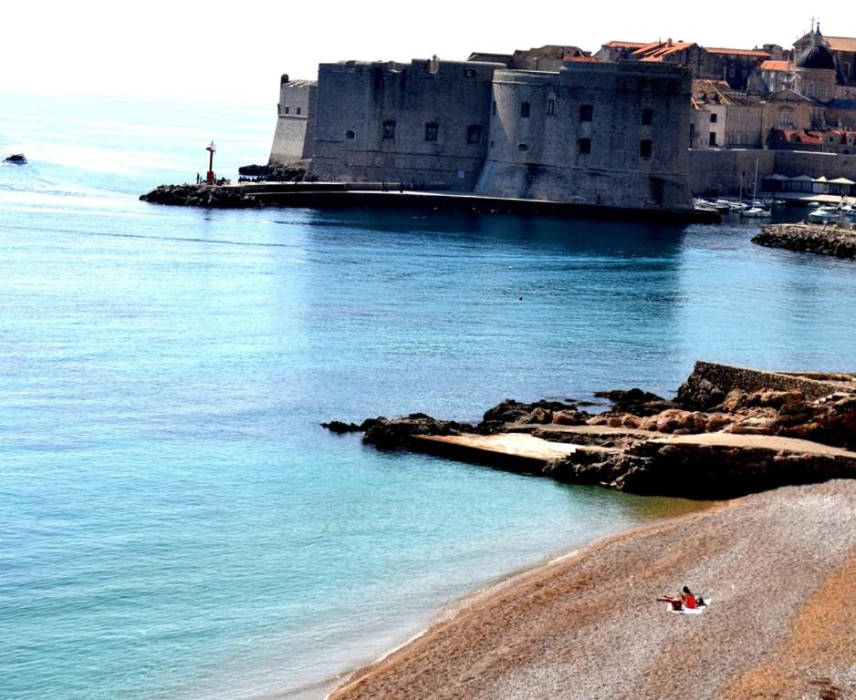 une personne se posant sur une plage de sable près de l'océan dans l'établissement Dubrovnik Stone House, à Dubrovnik