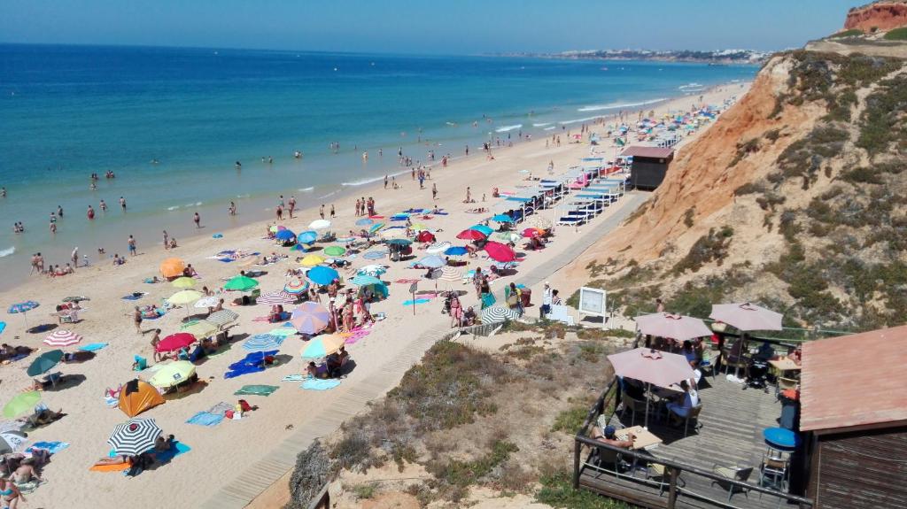 a group of people on a beach with umbrellas at Beach Falésia Alfamar in Albufeira