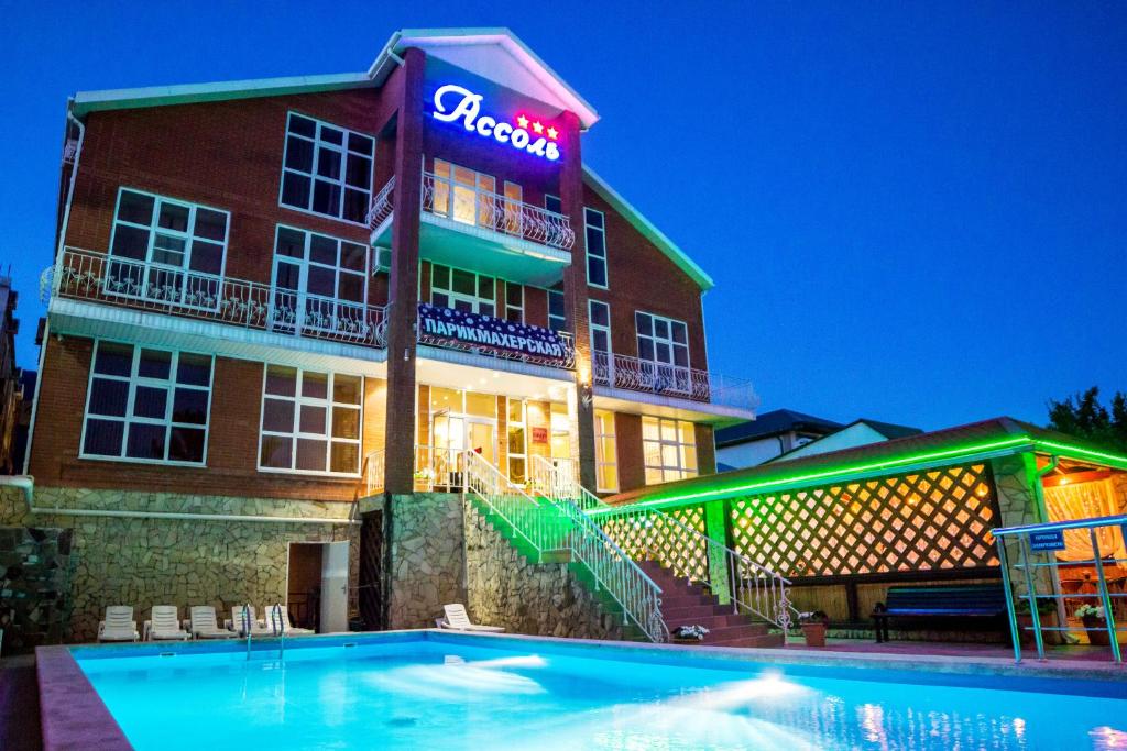 un hotel con piscina frente a un edificio en Assol, en Gelendzhik