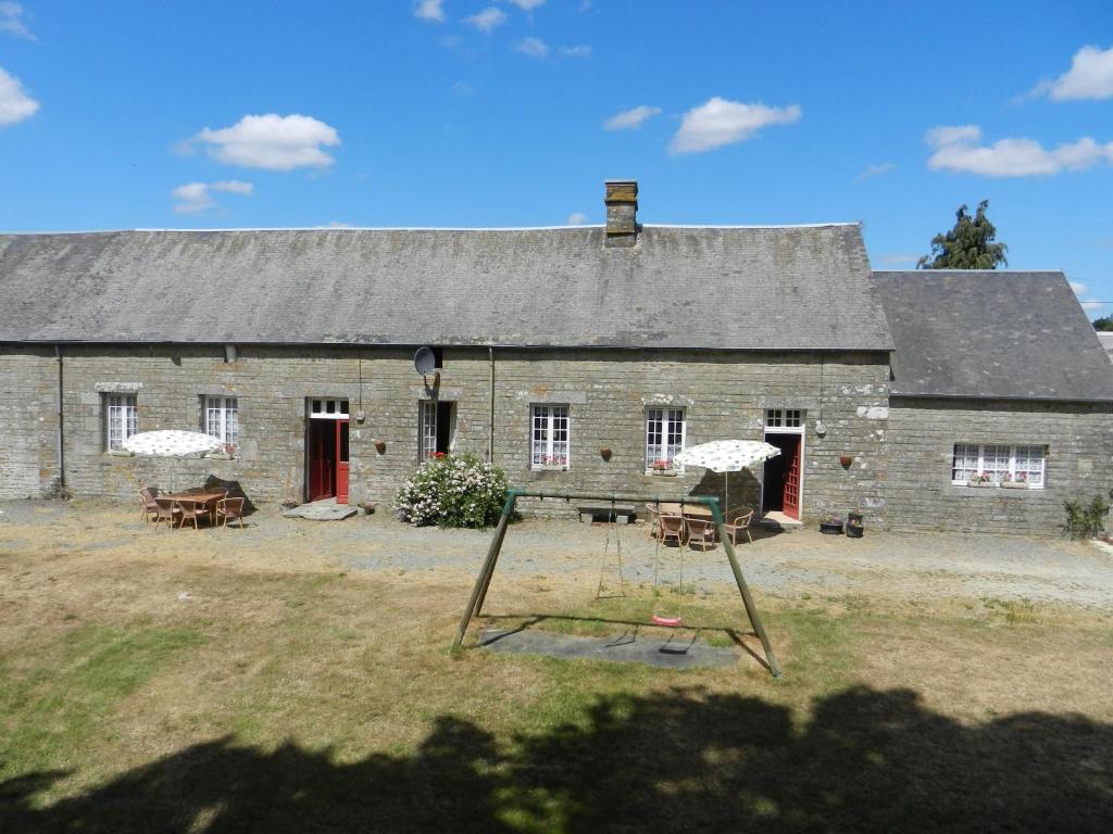 an old stone barn with a swing in front of it at Orbigny Vakantiewoningen in Saint-Pierre-la-Vieille
