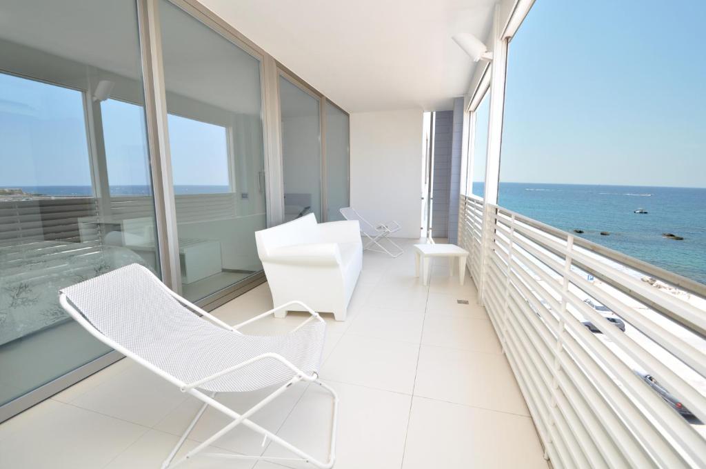 ガリポリにあるAttico 5 Vele by Salento Affittiの海の景色を望むバルコニー(白い椅子付)