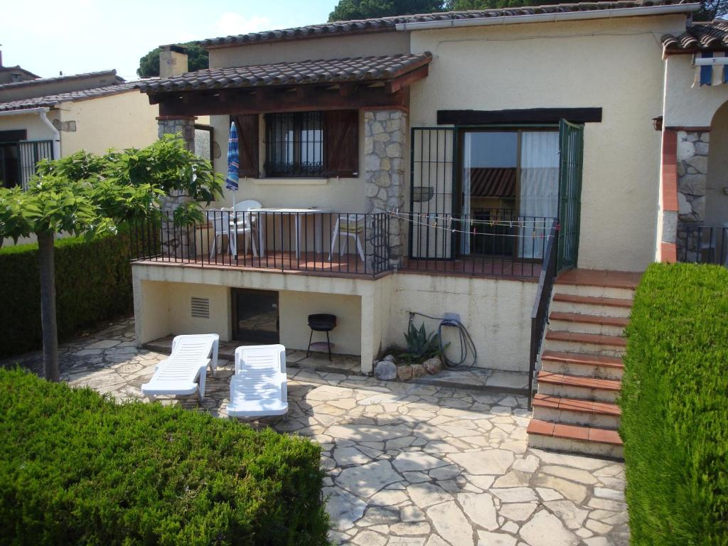a house with two lounge chairs and a balcony at Casa d'Or in L'Estartit