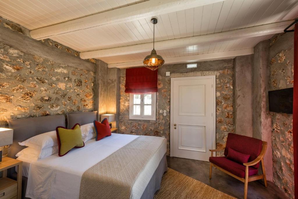 a bedroom with a bed and a red chair at North Point Rooms in Froúrion