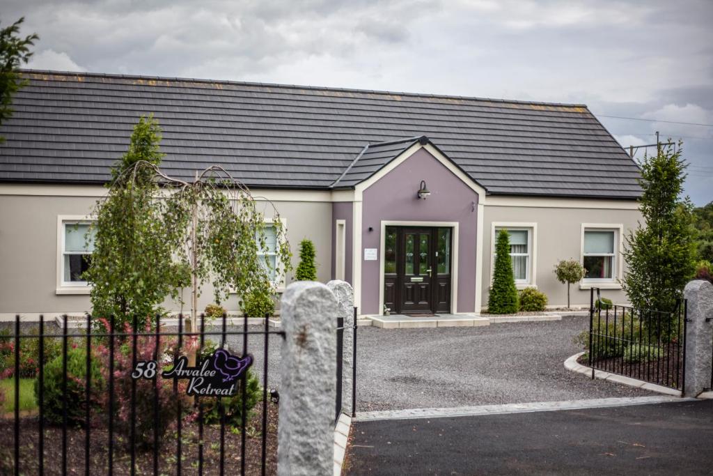 a white house with a black roof at Arvalee Retreat With Outdoor HotTub in Omagh