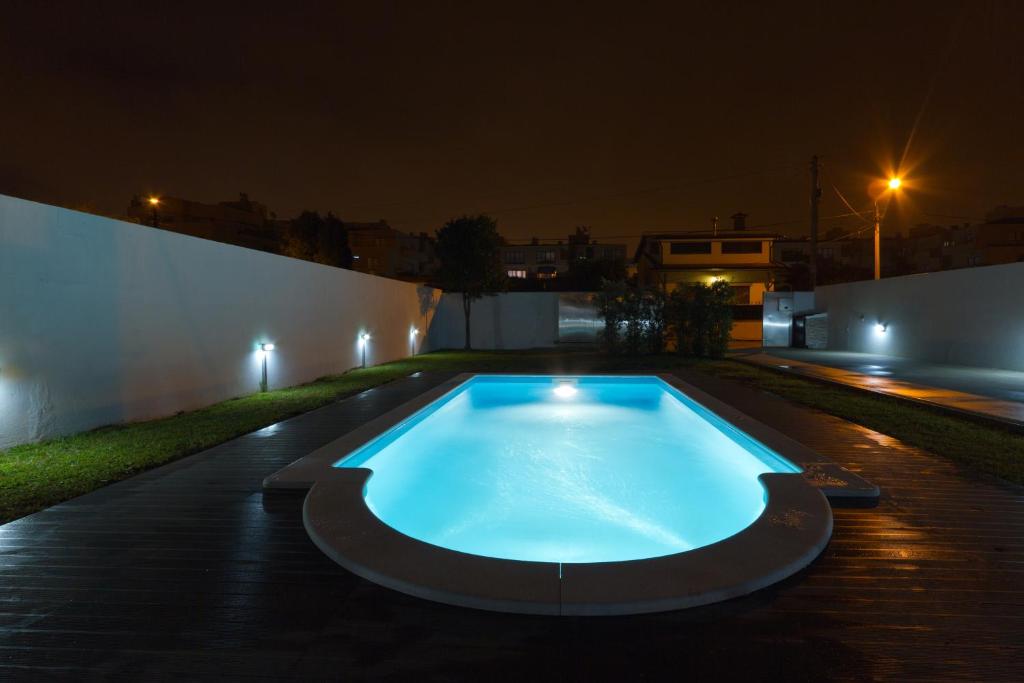a swimming pool in a backyard at night at Casa do Cerro in Madalena