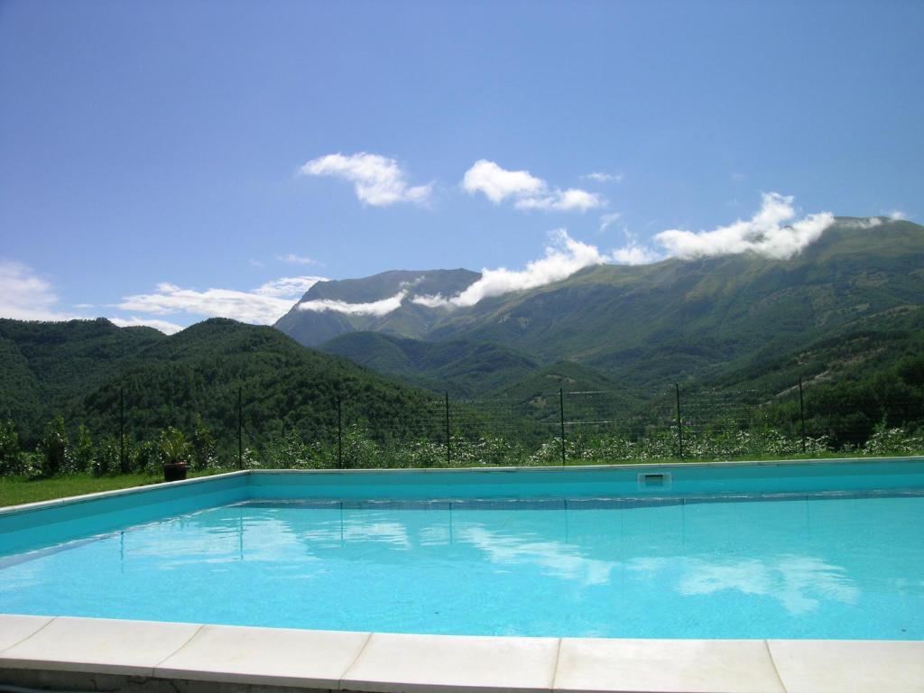 una grande piscina con montagne sullo sfondo di La Cittadella Dei Monti Sibillini a Montemonaco