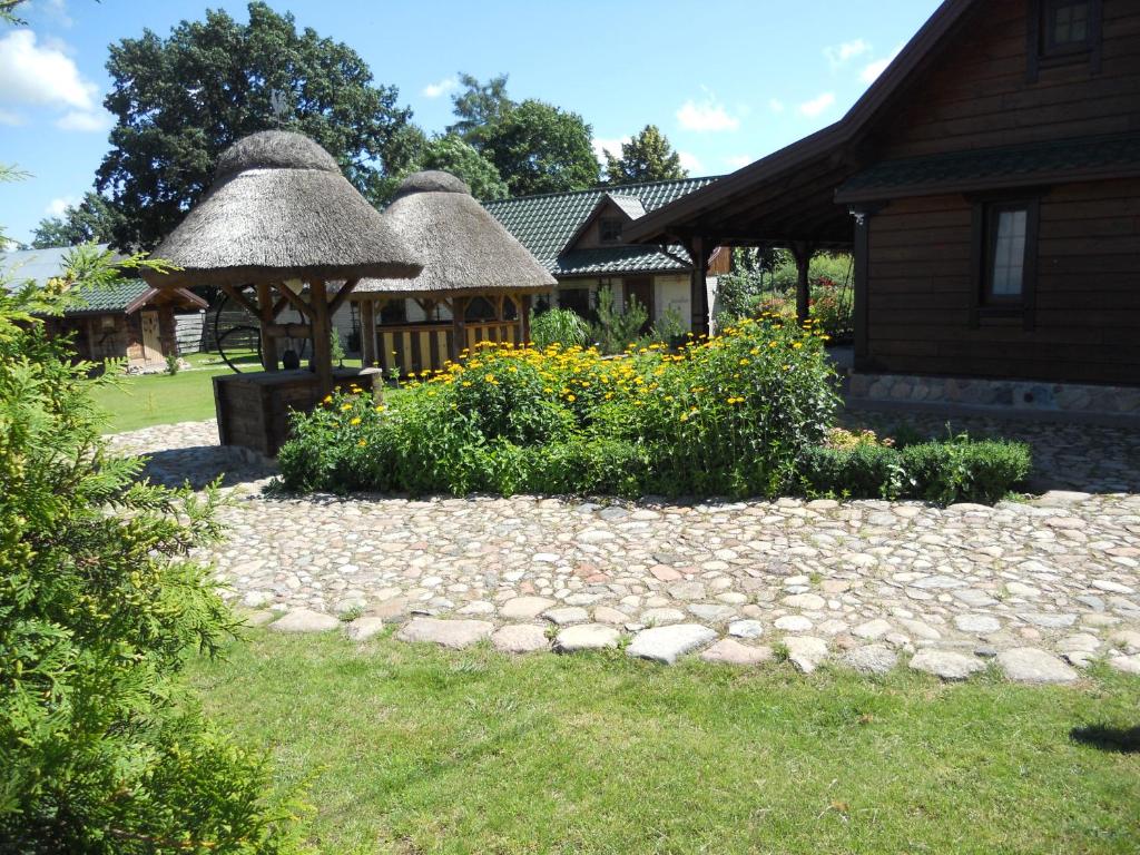 a garden with a stone walkway in front of a house at Dom pod Lipą in Jaminy