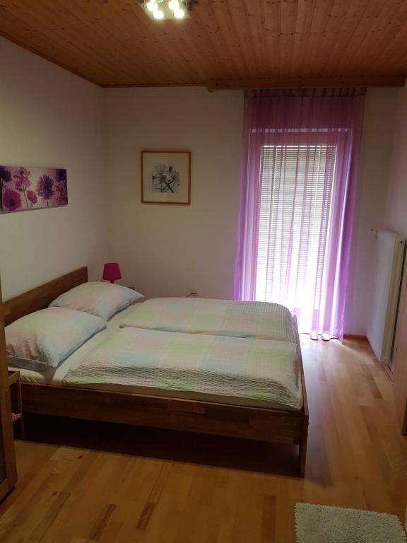 een slaapkamer met een bed en een raam met paarse gordijnen bij Apartment Familie Haupt in Bad Aussee