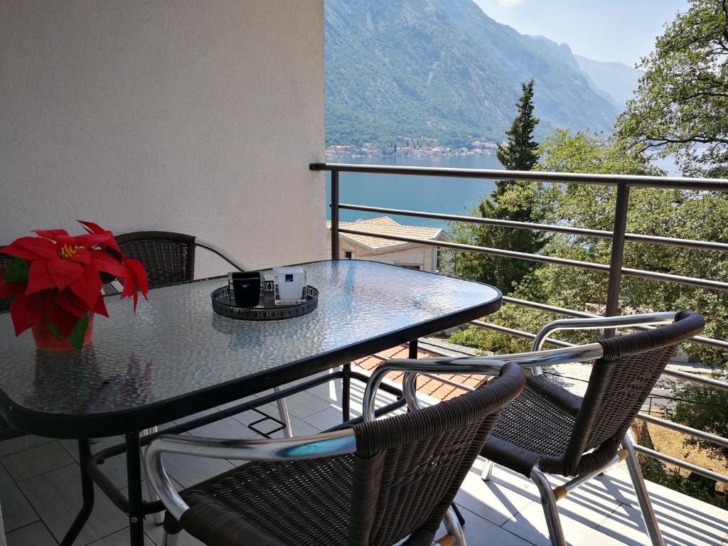 un tavolo e sedie su un balcone con vista di Apartment Babovic Orahovac Kotor a Kotor (Cattaro)