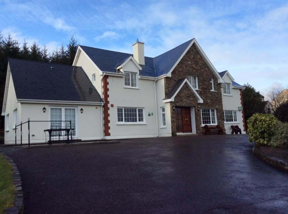 a white house with a black roof and a driveway at Sneem River Lodge Bed & Breakfast in Sneem