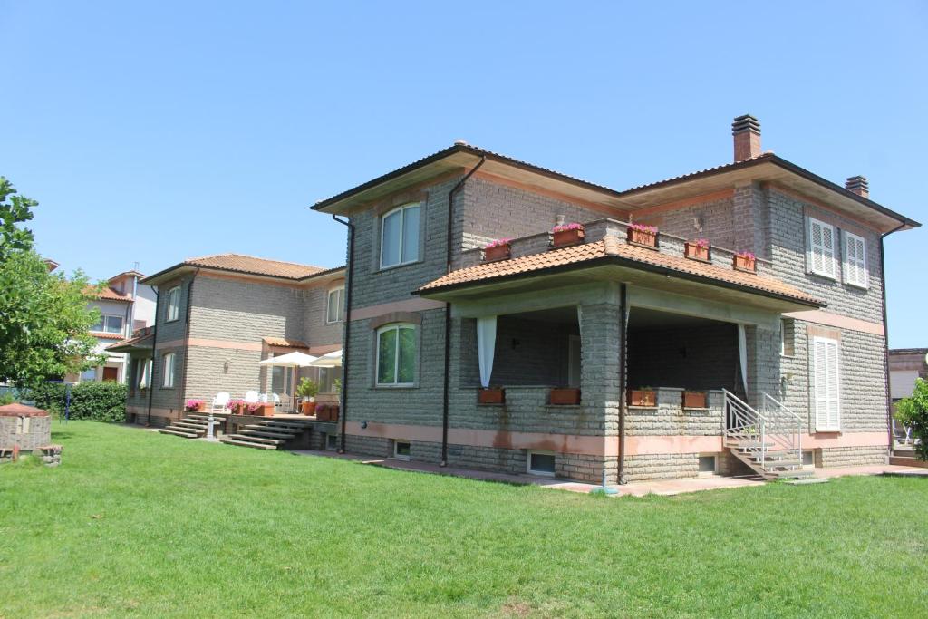 una casa grande con un césped verde delante de ella en La Casa di Sofia - Casa Vacanza Monterosi, en Monterosi