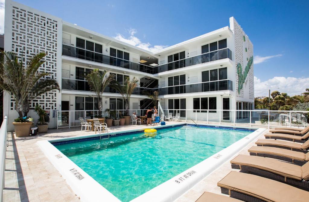 un bâtiment avec une piscine en face d'un bâtiment dans l'établissement Premiere Hotel, à Fort Lauderdale