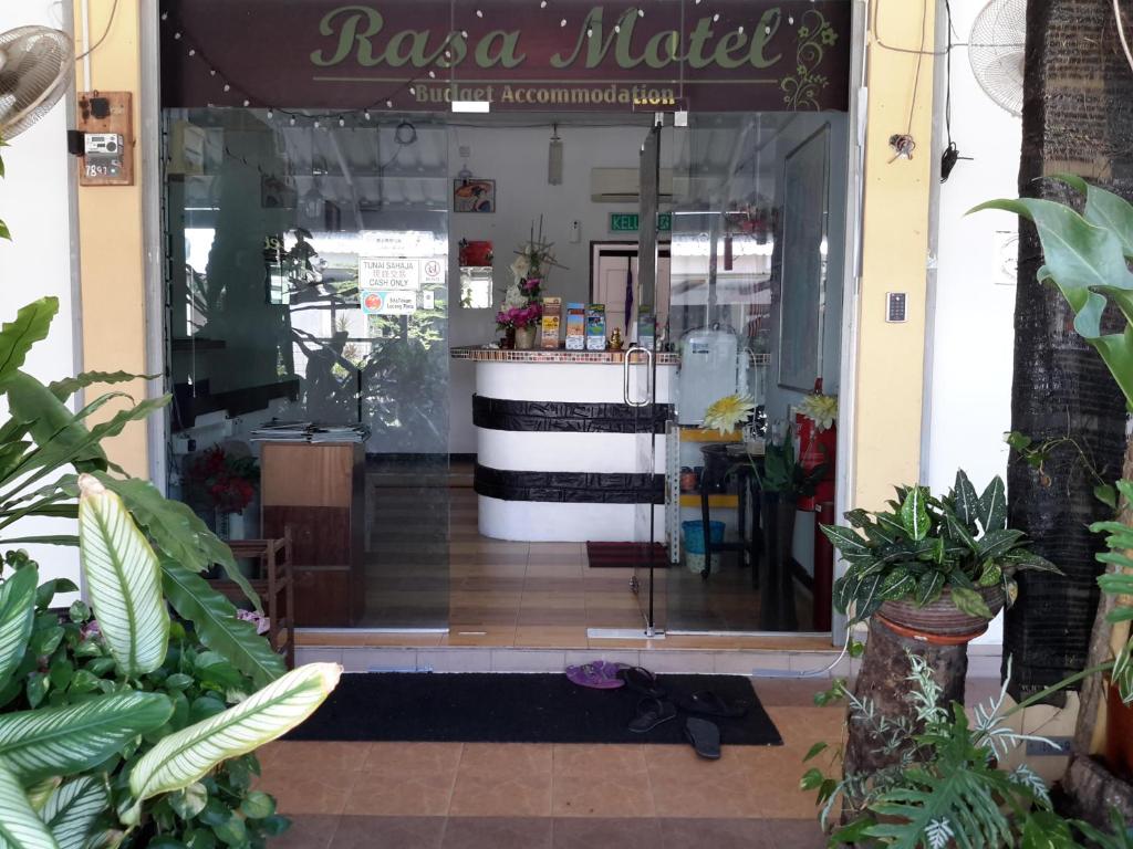 una porta d'ingresso di un negozio di fiori con piante di Rasa Motel a Batu Ferringhi