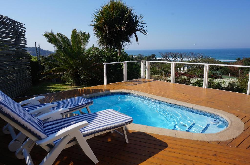una piscina en una terraza con 2 sillas al lado en CodsView Beach House, en Pennington