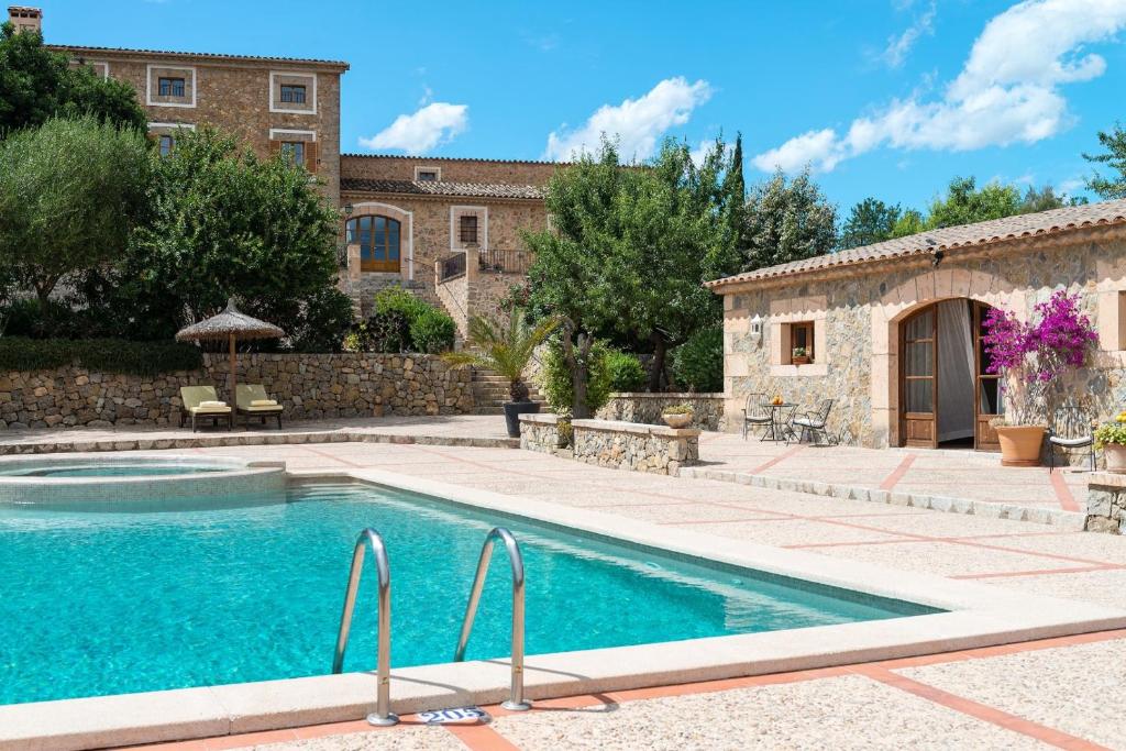 uma piscina em frente a uma casa com um edifício em Fincahotel Can Estades em Calvià