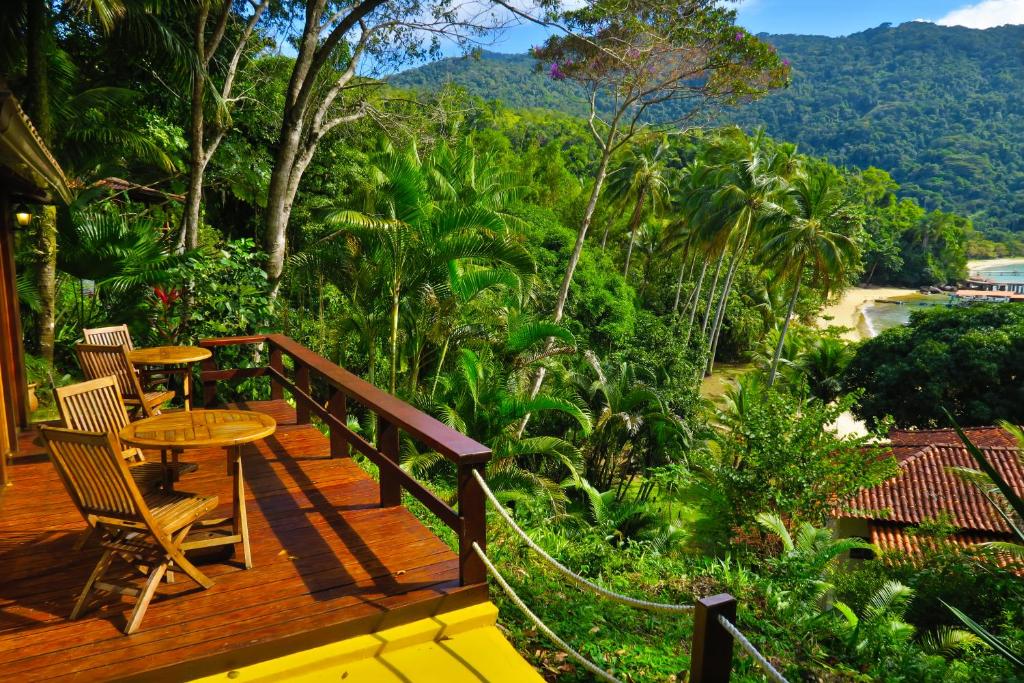 une terrasse en bois avec une table et des chaises. dans l'établissement Atlantica Jungle Lodge, à Abraão