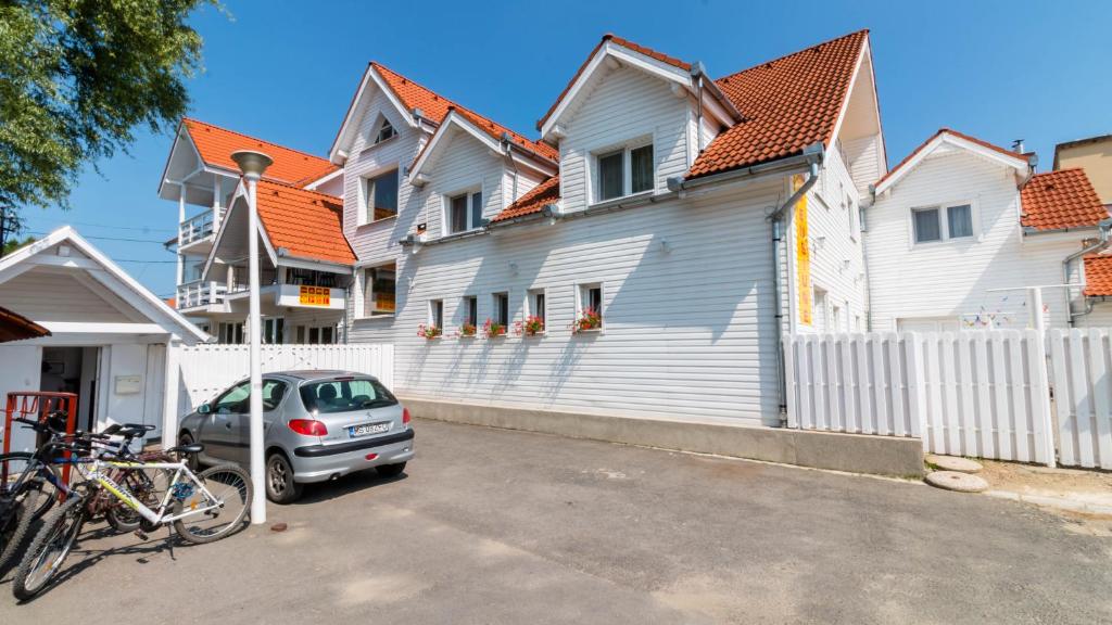 a car parked in front of a white house at Pension Aquaris in Sighişoara