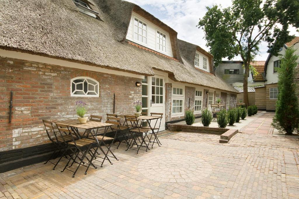 een patio met tafels en stoelen voor een gebouw bij "Karel de Grote" Bergen in Bergen