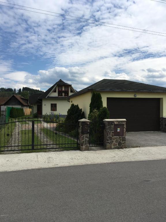 a house with two trash cans in front of a fence at Garden 35 in Ivachnová