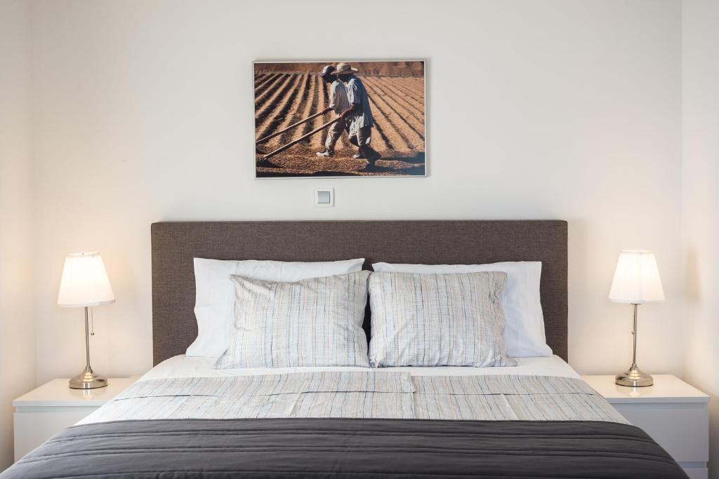 a bedroom with a large bed with two lamps at Apartments Nino 1 in Zadar