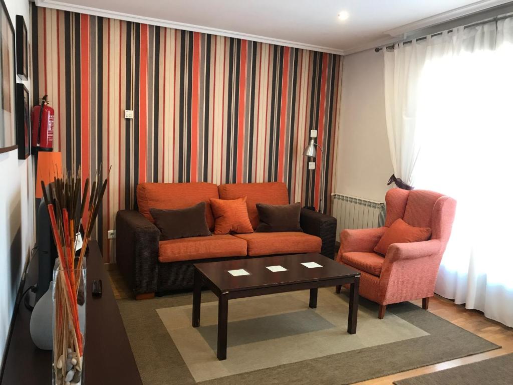 - un salon avec un canapé et deux chaises dans l'établissement Apartamento Horreo Centro Cangas de Onis, à Cangas de Onís