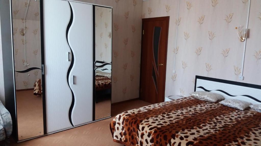 - une chambre avec un lit et un grand miroir dans l'établissement Agrousadba Nesvizh, à Nyasvizh