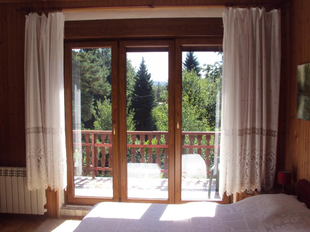 een slaapkamer met een bed en een groot glazen raam bij PLITVICE KONAK Daic in Plitvička Jezera