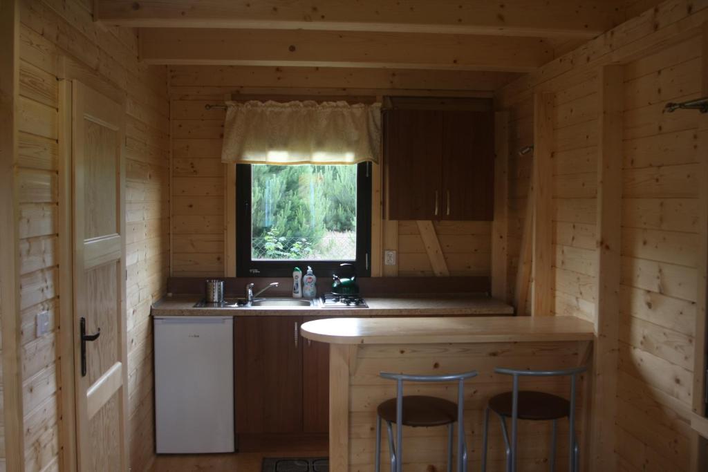 a kitchen in a log cabin with a sink and a window at Domki Letniskowe "Przy Parku" in Wisełka