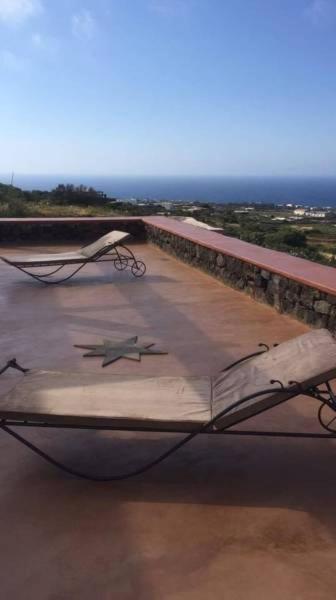 łóżko na dachu budynku z widokiem na ocean w obiekcie Horizon Pantelleria w mieście Pantelleria