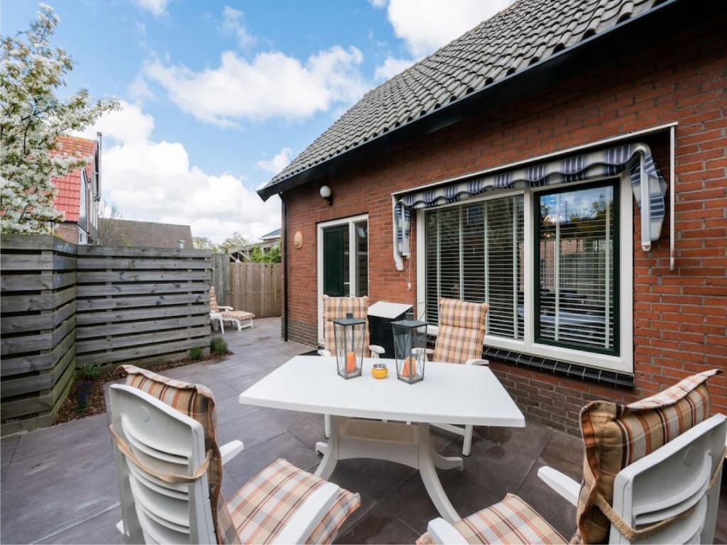 un patio con una mesa blanca y sillas en Catharina Texel, en Den Burg