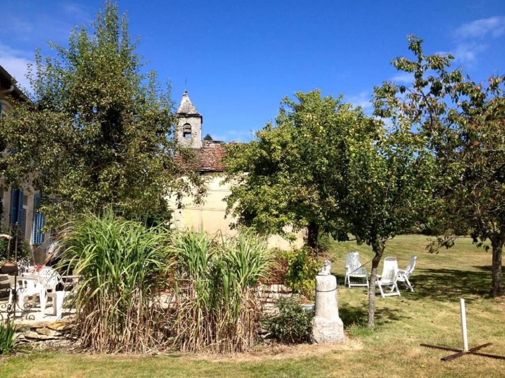 a yard with white chairs and a building at Les Gîtes De Morville in Malaumont