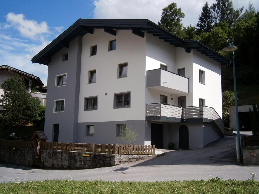 una casa blanca con techo negro en Ferienwohnung Nuener, en Grins