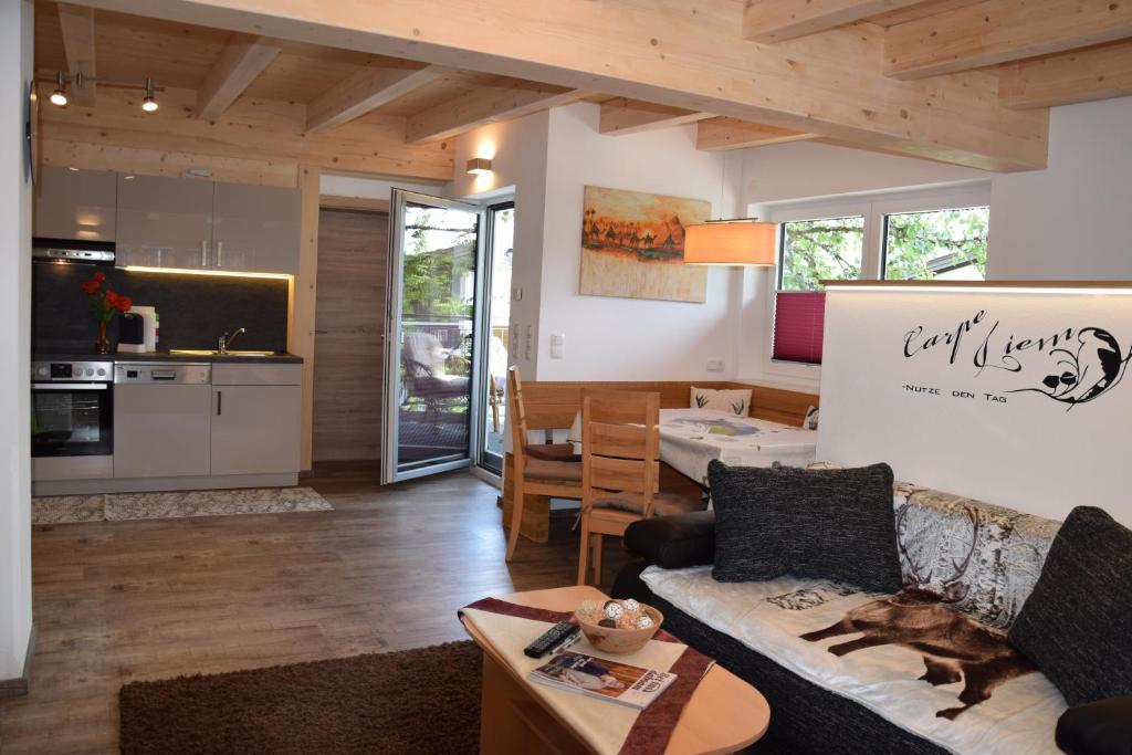 a living room with a couch and a kitchen at Ferienwohnung Trixl in Hochfilzen