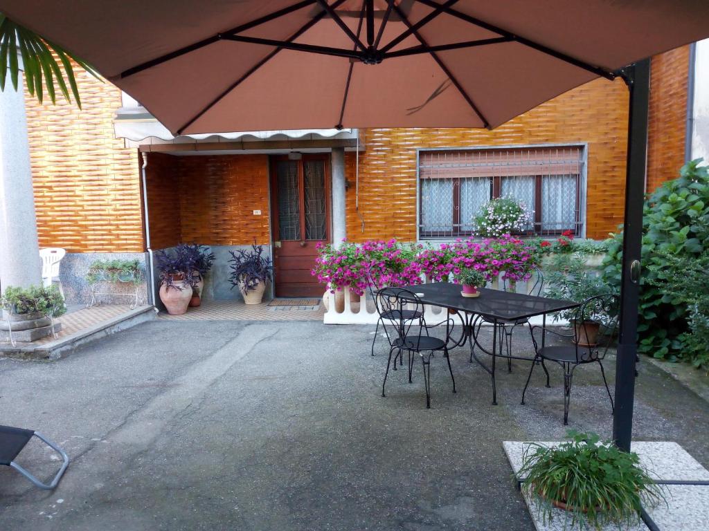 a table and chairs under an umbrella in front of a house at Le Palme Apartment in Gargallo