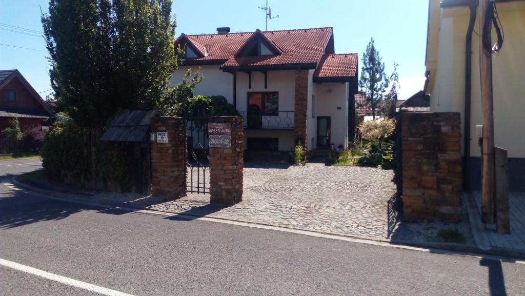 a house with a gate on the side of a street at Privat Greenland in Liptovský Mikuláš