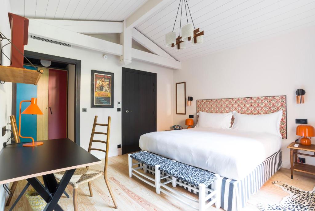 a bedroom with a large bed and a table at La Guitoune in Pyla-sur-Mer