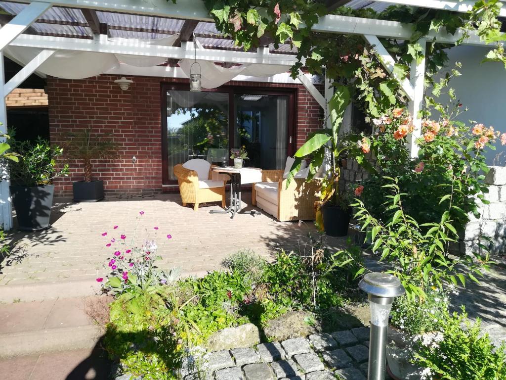eine Terrasse mit einem Tisch und einigen Pflanzen und Blumen in der Unterkunft Bokelrehm in Bokelrehm