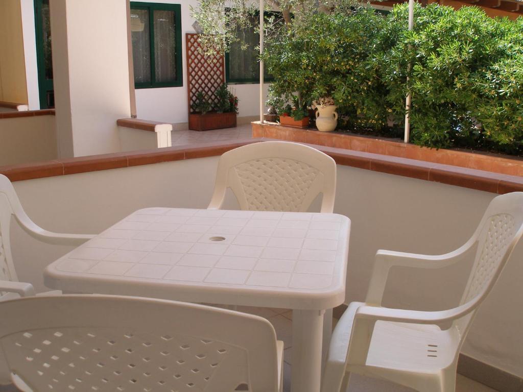 a white table and chairs in a room with plants at Hotel Residence Villa Ascoli in Vieste