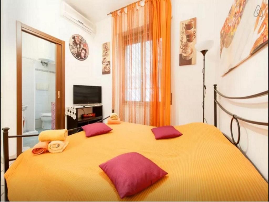 ローマにあるSan Giovanni In Laterano Daniela Apartmentのベッドルーム(紫色の枕が付いた大きな黄色のベッド付)