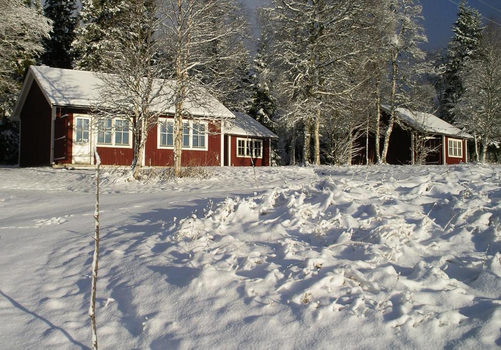 a red house with snow in front of it at Backs Semesterby in Duved