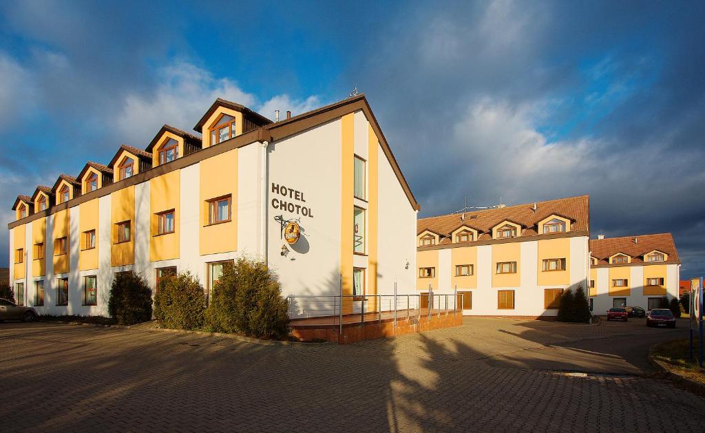un grande edificio con un cartello sul lato di Hotel Chotol a Horoměřice