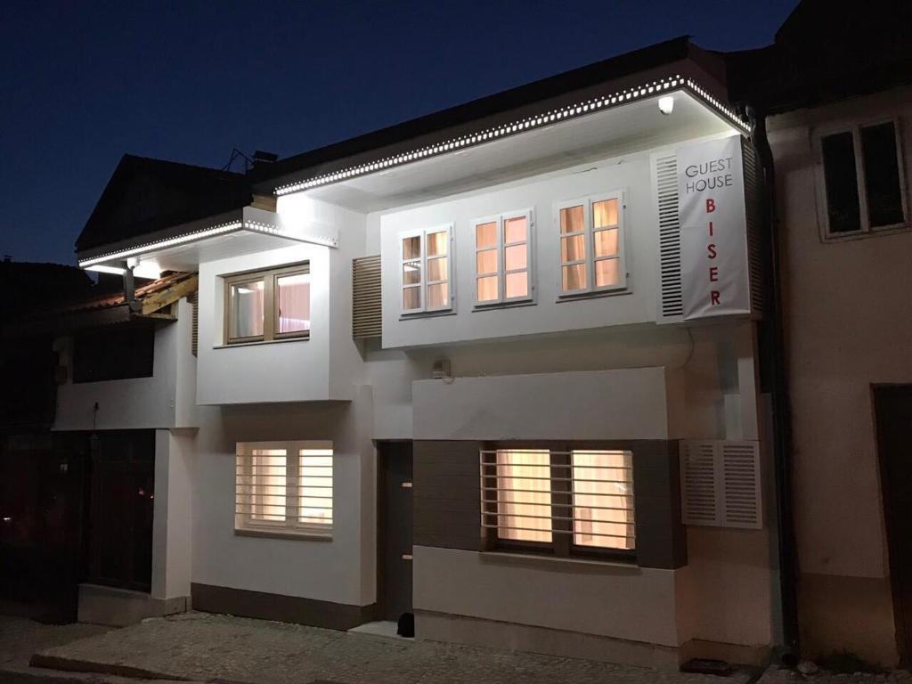 un edificio blanco con ventanas iluminadas por la noche en Guesthouse Biser, en Sarajevo