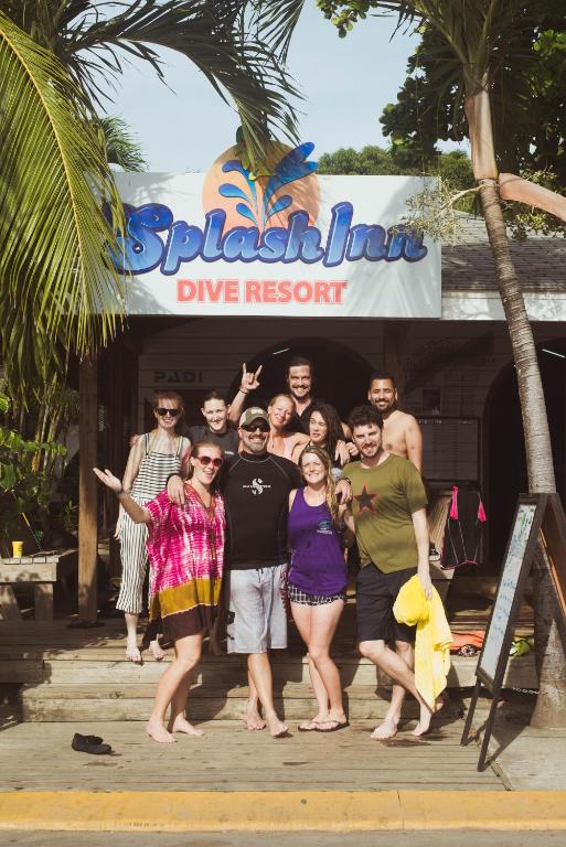 a group of people posing in front of a dive resort at Splash Inn Dive Resort & Villas in West End