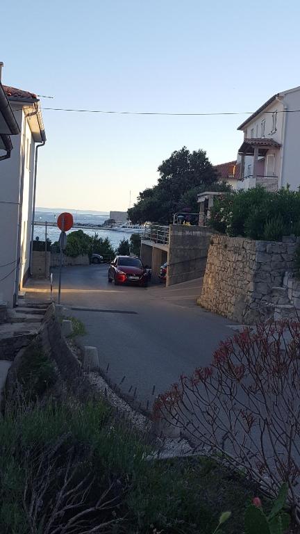 a car parked on a street next to a house at Matušanka Apartment in Rab