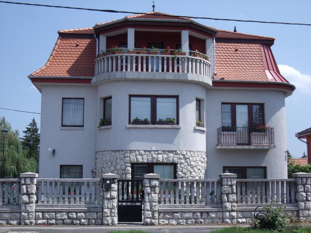 a white house with a balcony on top of it at Sasi Panzió 2 in Esztergom