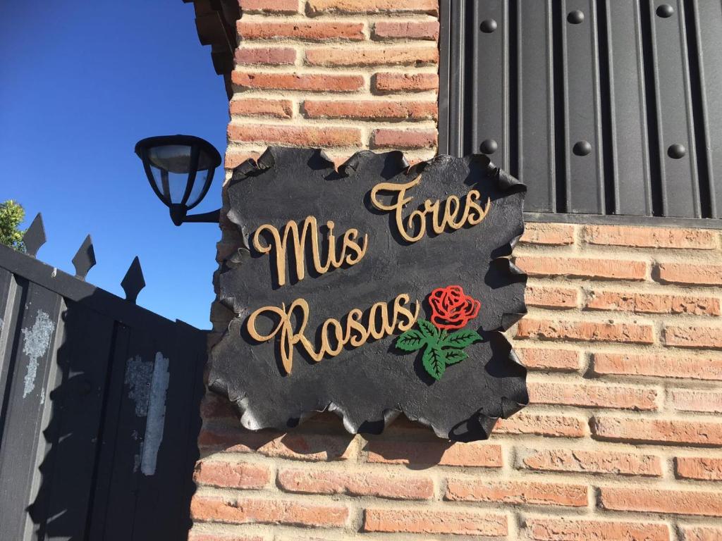 ein Schild an der Seite eines Backsteingebäudes in der Unterkunft Mis Tres Rosas in La Barca de la Florida