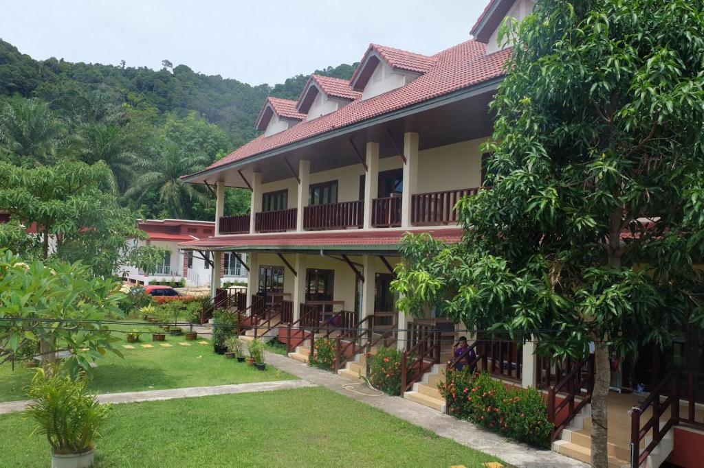 a building with a green yard in front of it at Phumin Apartment in Ko Lanta