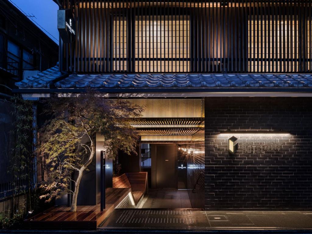uma casa de tijolos com uma árvore em frente em Kyoto Granbell Hotel em Quioto